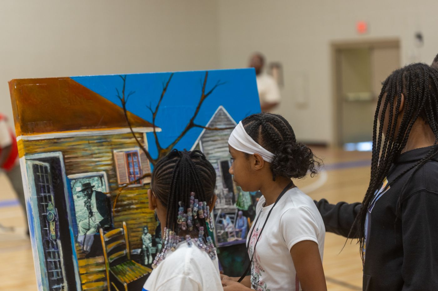 Campers look closely at a collage of a house